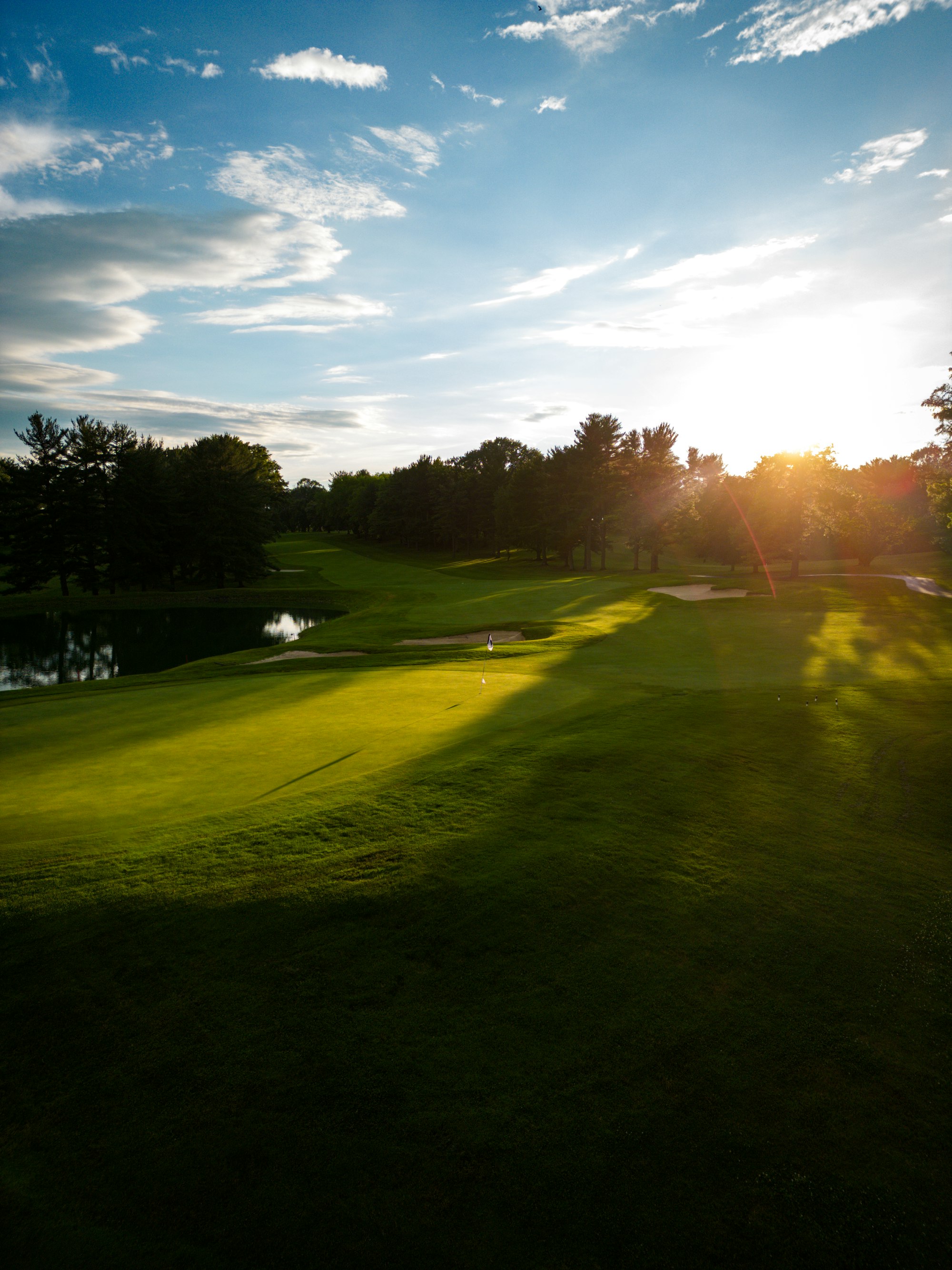 A green and water on the course at golden hour