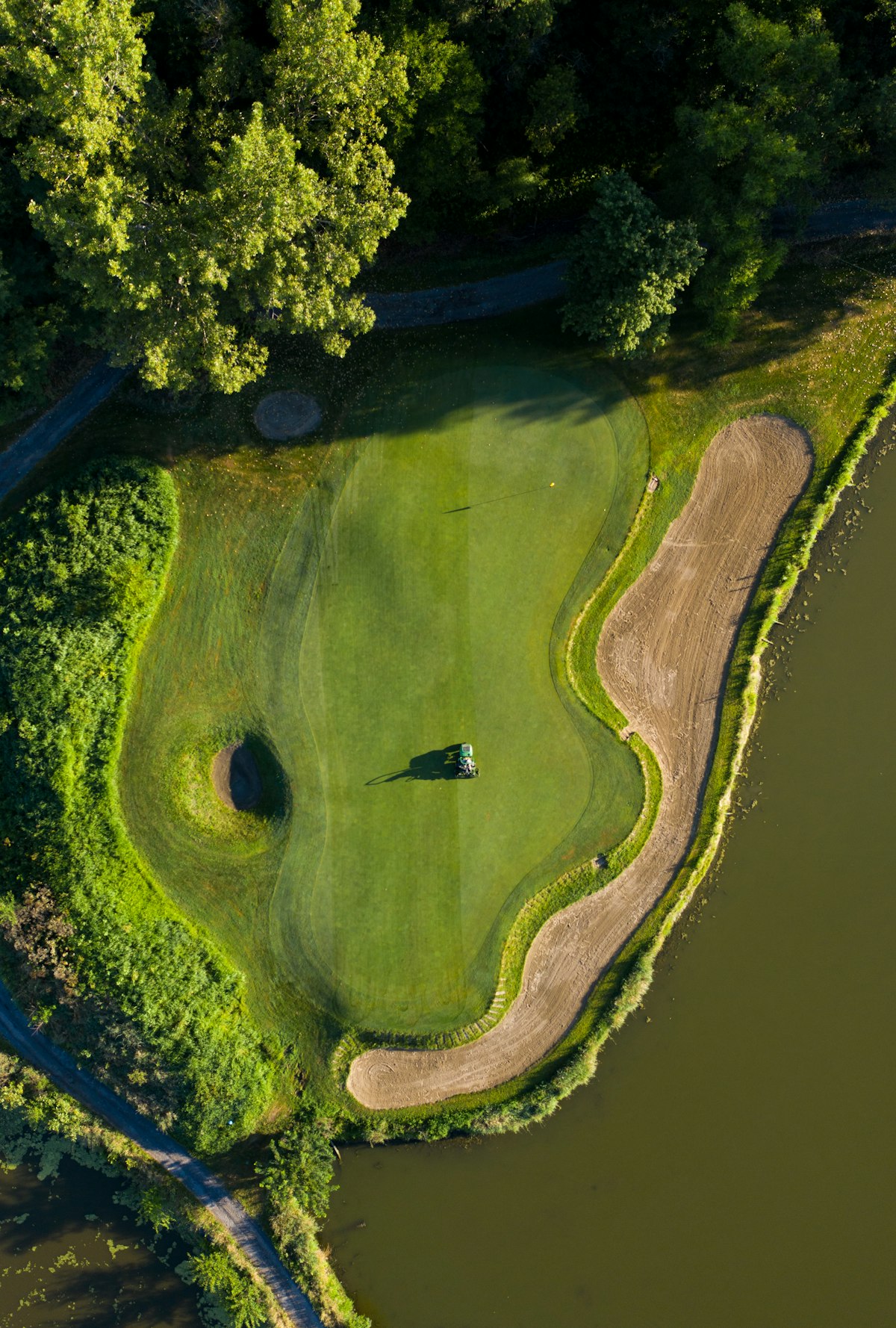 A green beside water and a tree line on the course